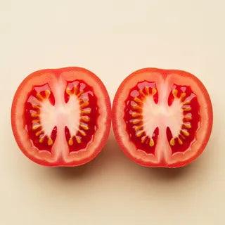 A halved ripe tomato — the natural source of lycopene — showing red flesh and yellow seeds